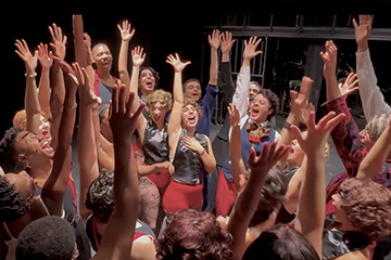 NWSA Ochestra during a live performance on stage with a vocalist

